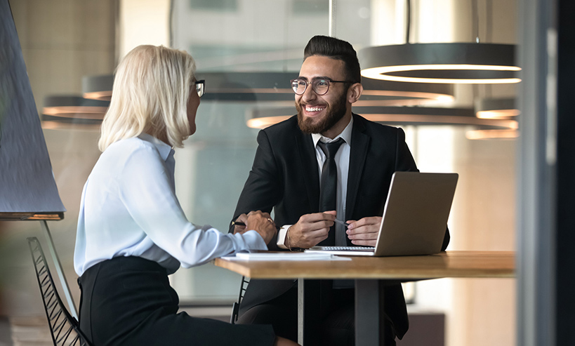 European Arabian business partners negotiating sit at desk hold pens pc notepads on table, diverse client and boss meet for solve issues, plan future cooperation, making profitable proposition concept