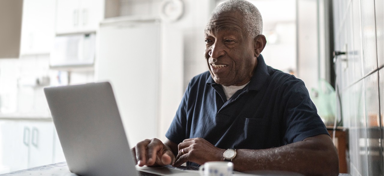 Senior man working at laptop at home