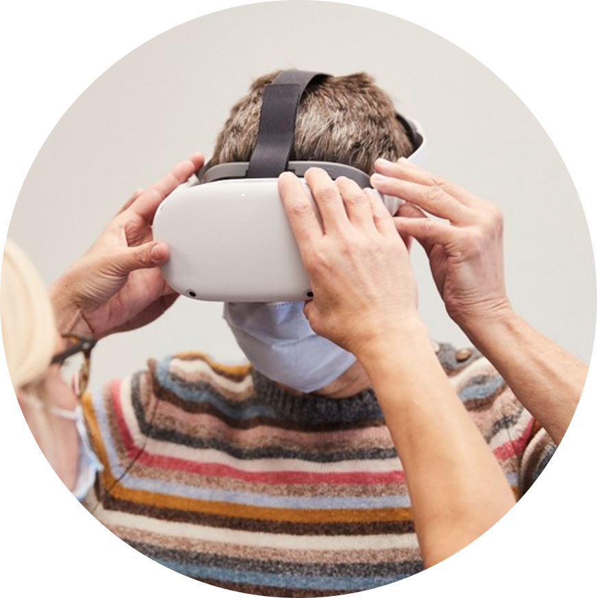 The trainer helps the patient put on the VR headset
