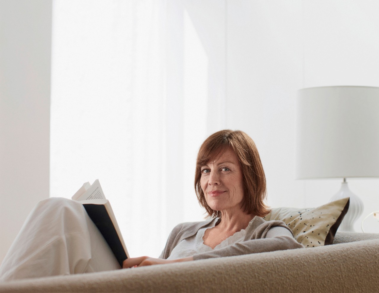 Woman on sofa reading book
